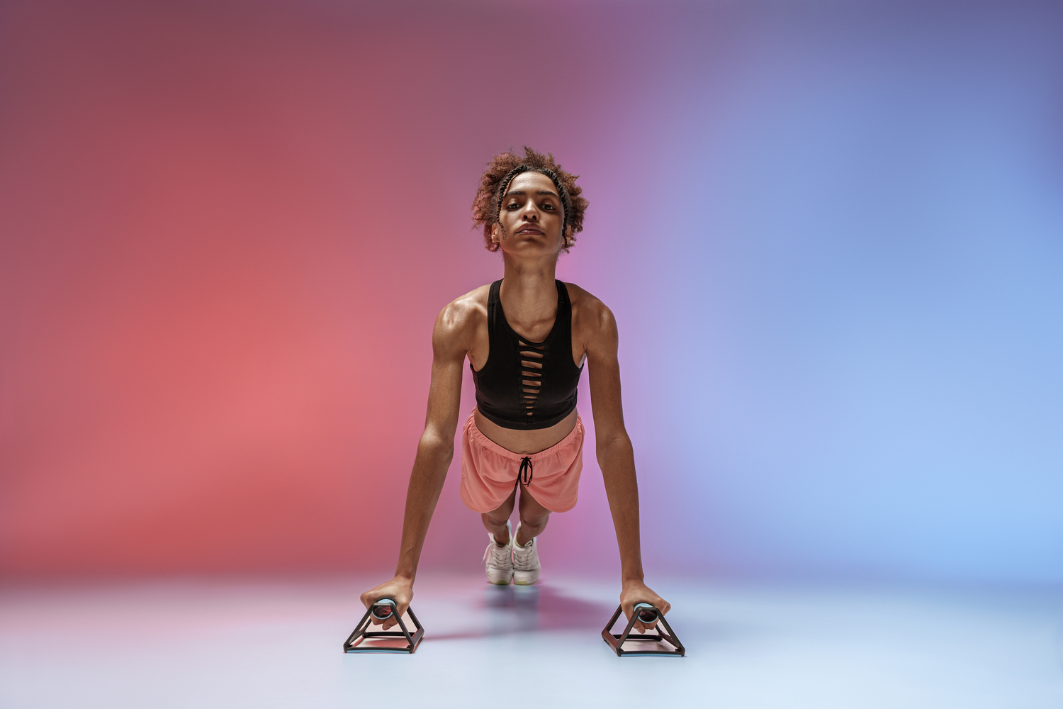 Athlete powering through push-ups under colour lights — Clean Energy Pre-Workout