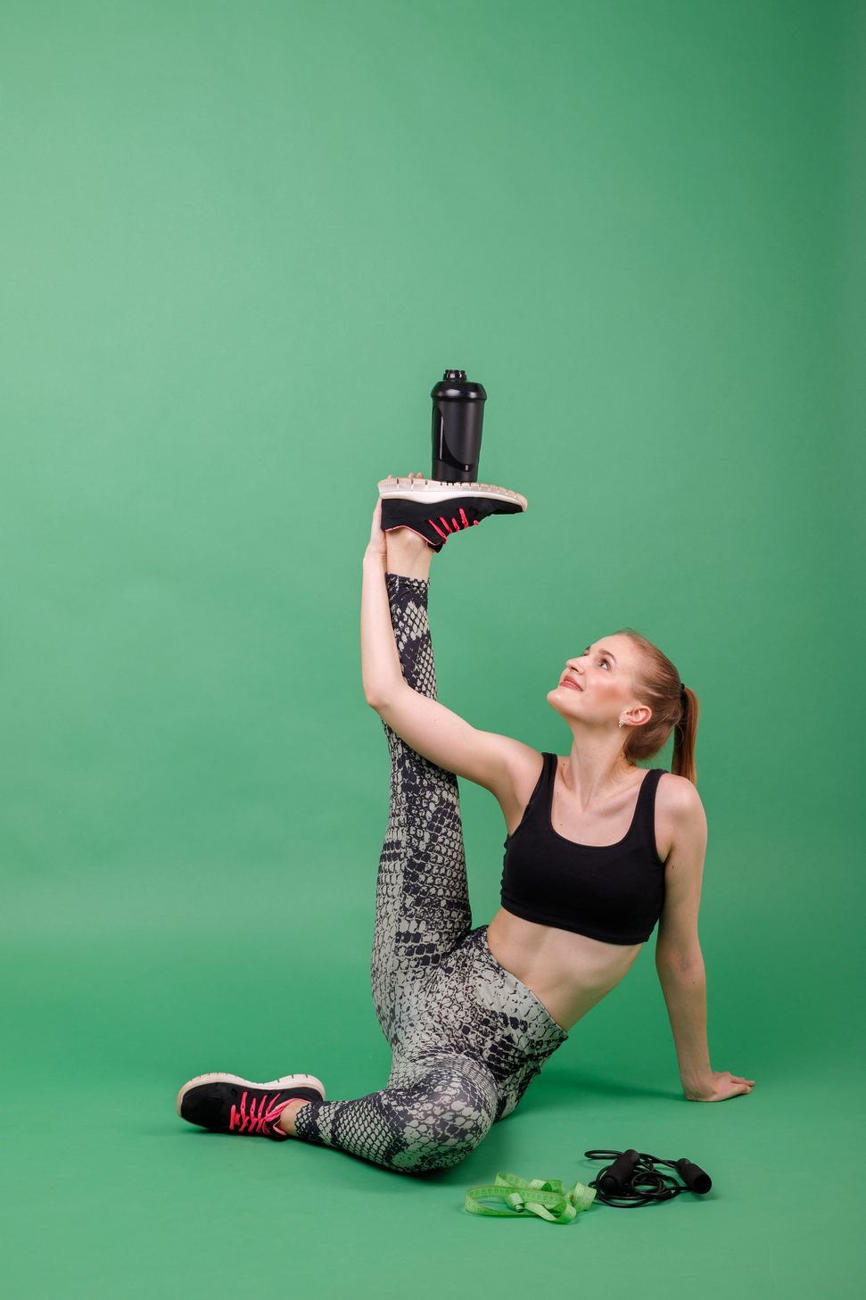 Athlete balancing a drink bottle mid-stretch — Electrolyte Hydration